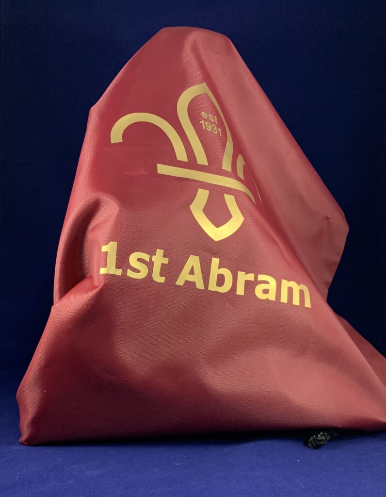 1st Abram branded drawstring bag.

The bag is a dark red/brown colour, with gold lettering and scouting logo.