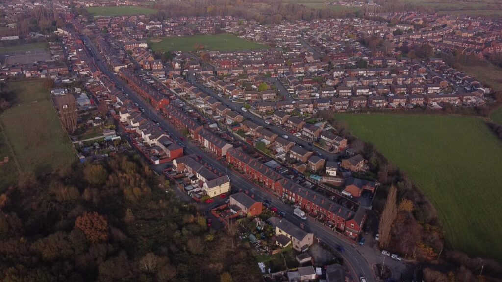 Aerial shot of Abram, showing the houses on the main road and many streets branching off it.